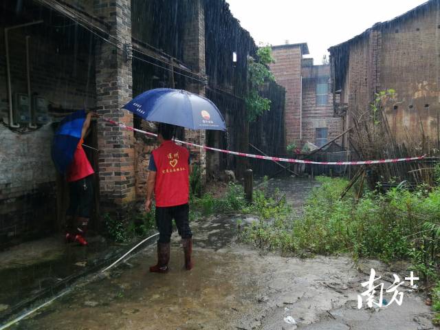 黨群志愿者冒雨拉起警戒線。